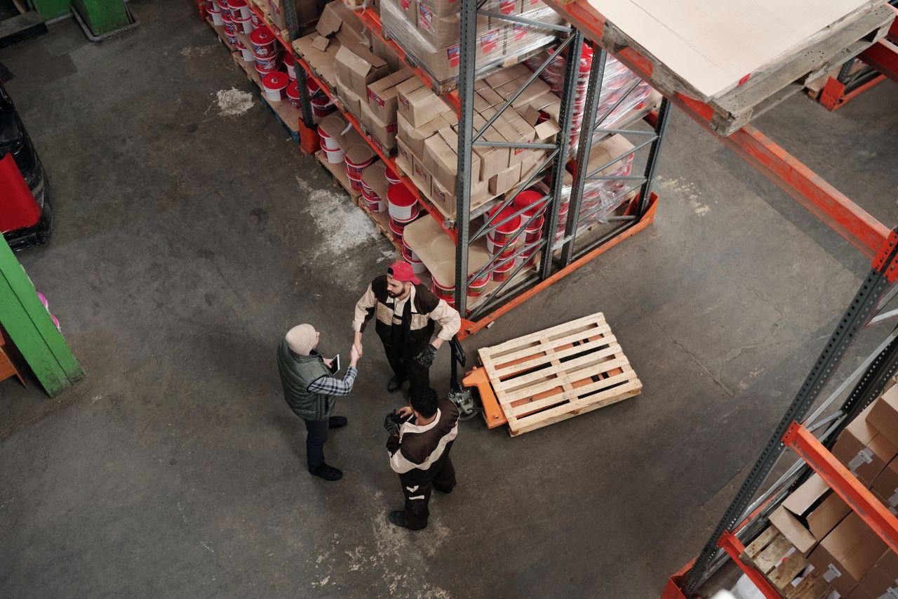 Services High angle view of workers discussing logistics in a warehouse setting.